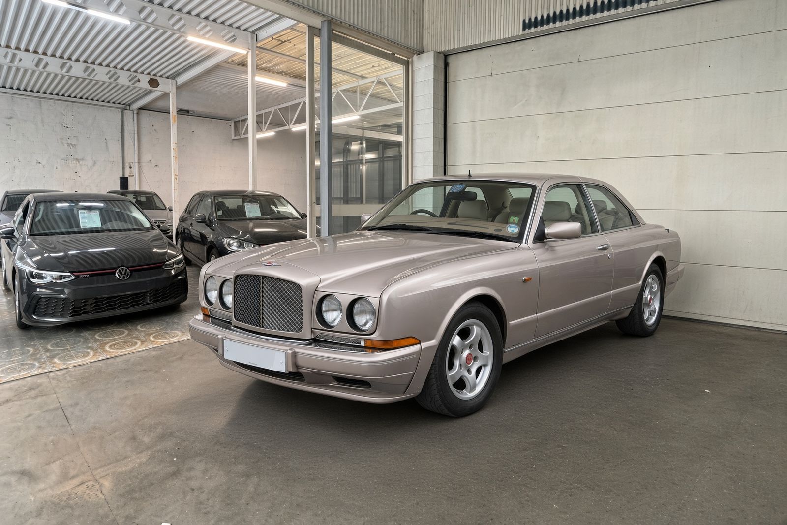 Champagnekleurige Bentley Continental R coupé in de showroom van JW Motors in Deurne